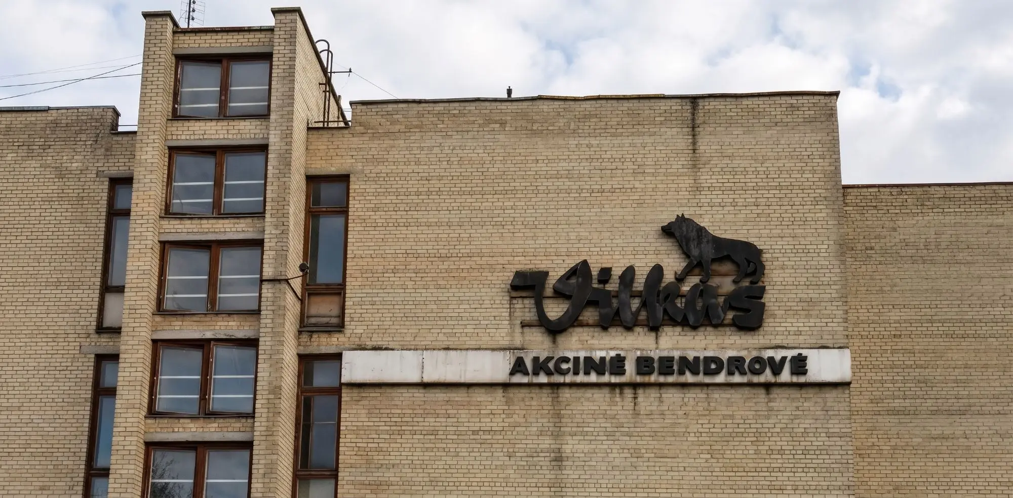 AB „Vilkas“ iškaba ant plytų pastato fasado – vienas pirmųjų Artrekos darbų