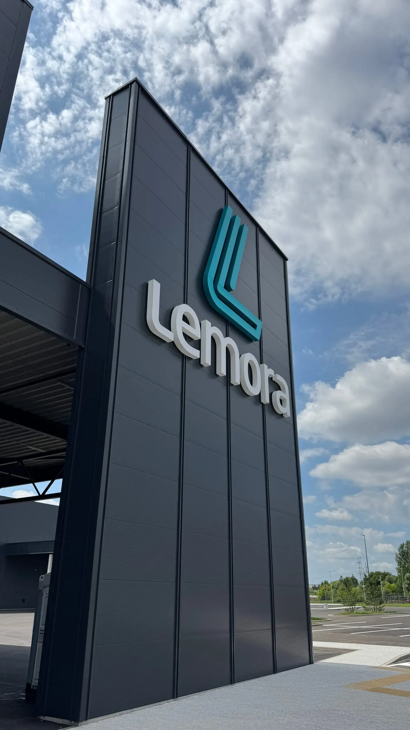 Lemora tūrinis logotipas ant pastato kampo