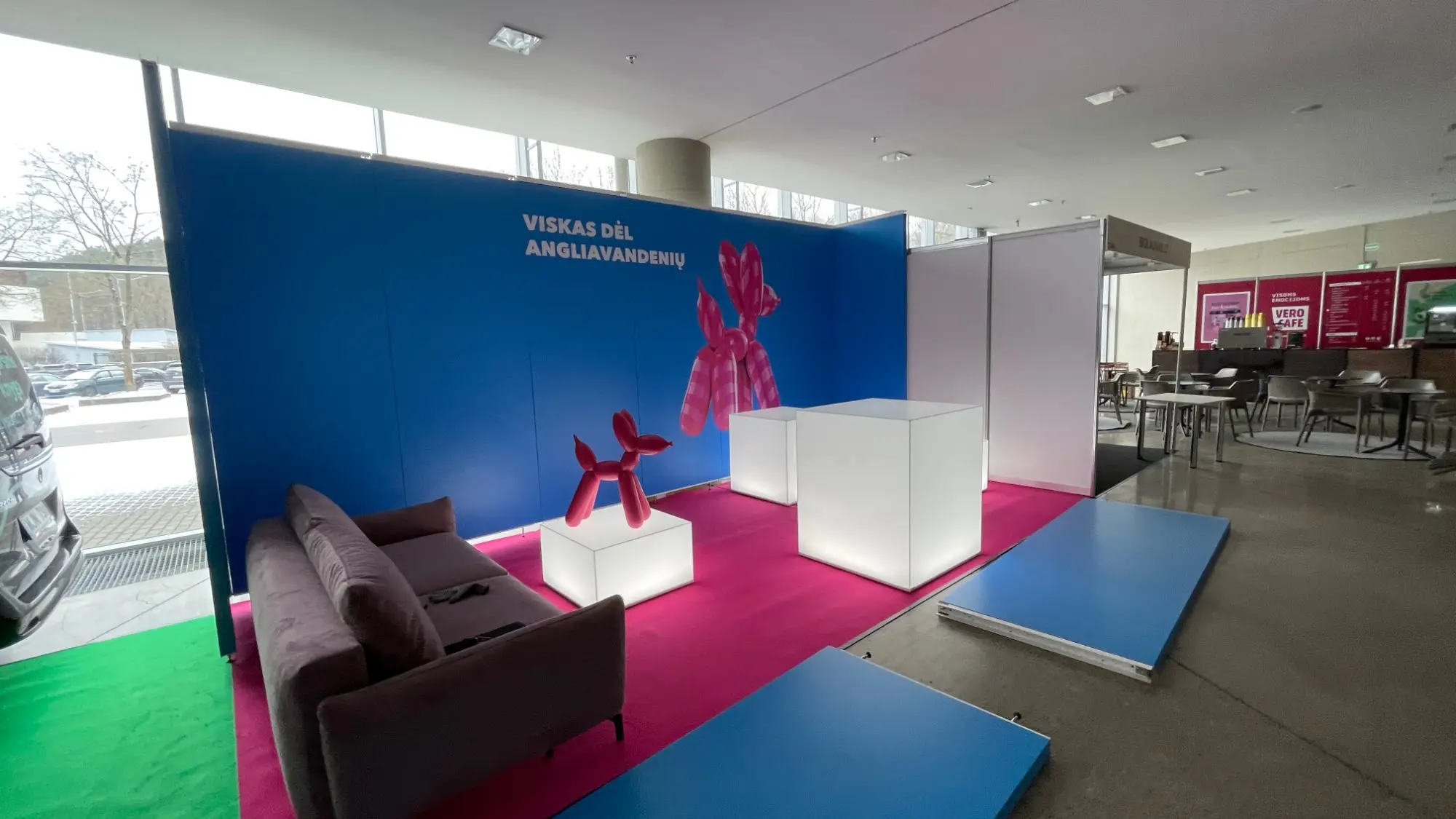 Parodos stendas „Viskas dėl angliavandenių“ su rožiniu balloon dog ir šviečiančiais kubais