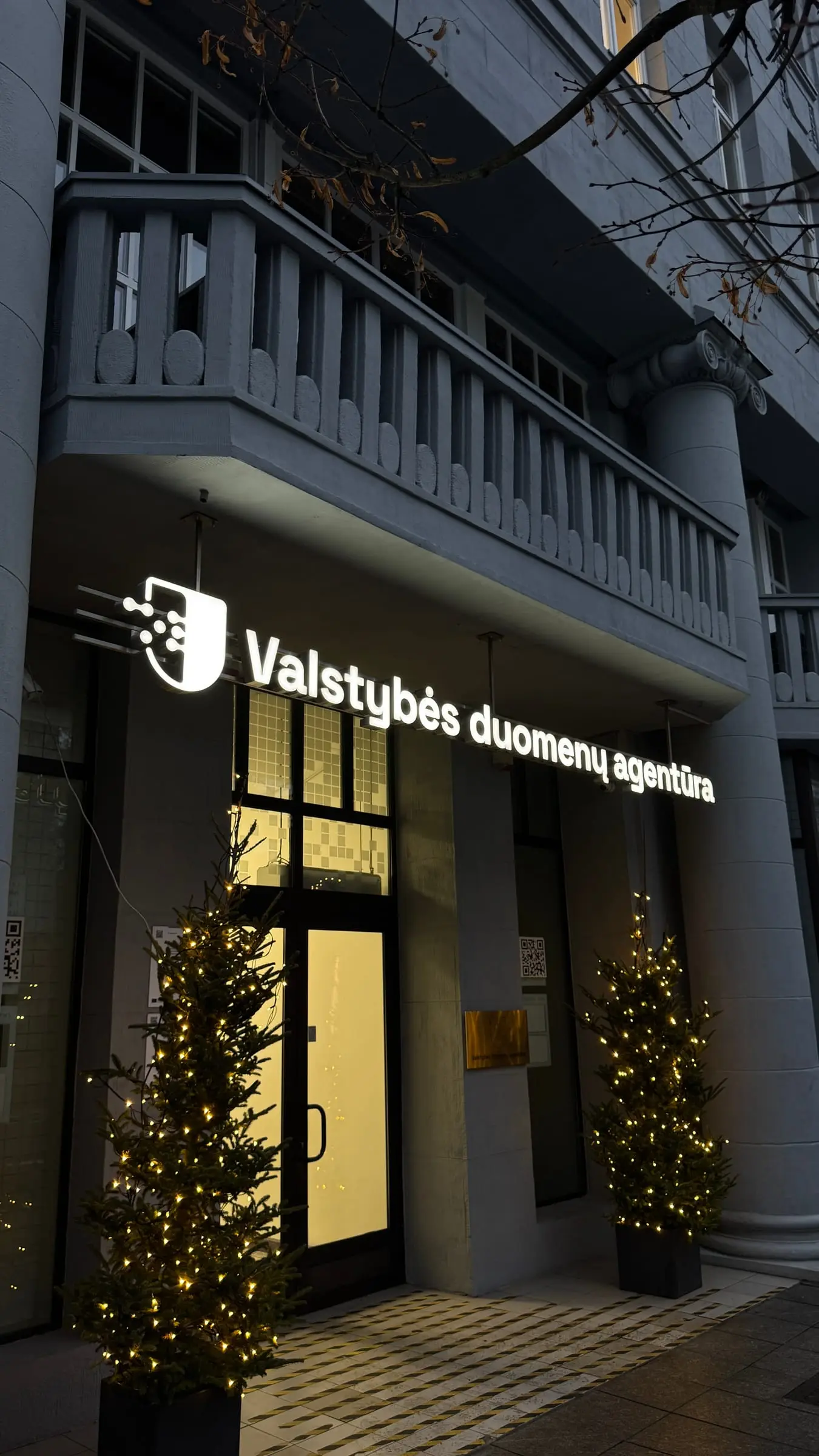 Šviečiančios raidės „Valstybės duomenų agentūra“ virš įėjimo vakare