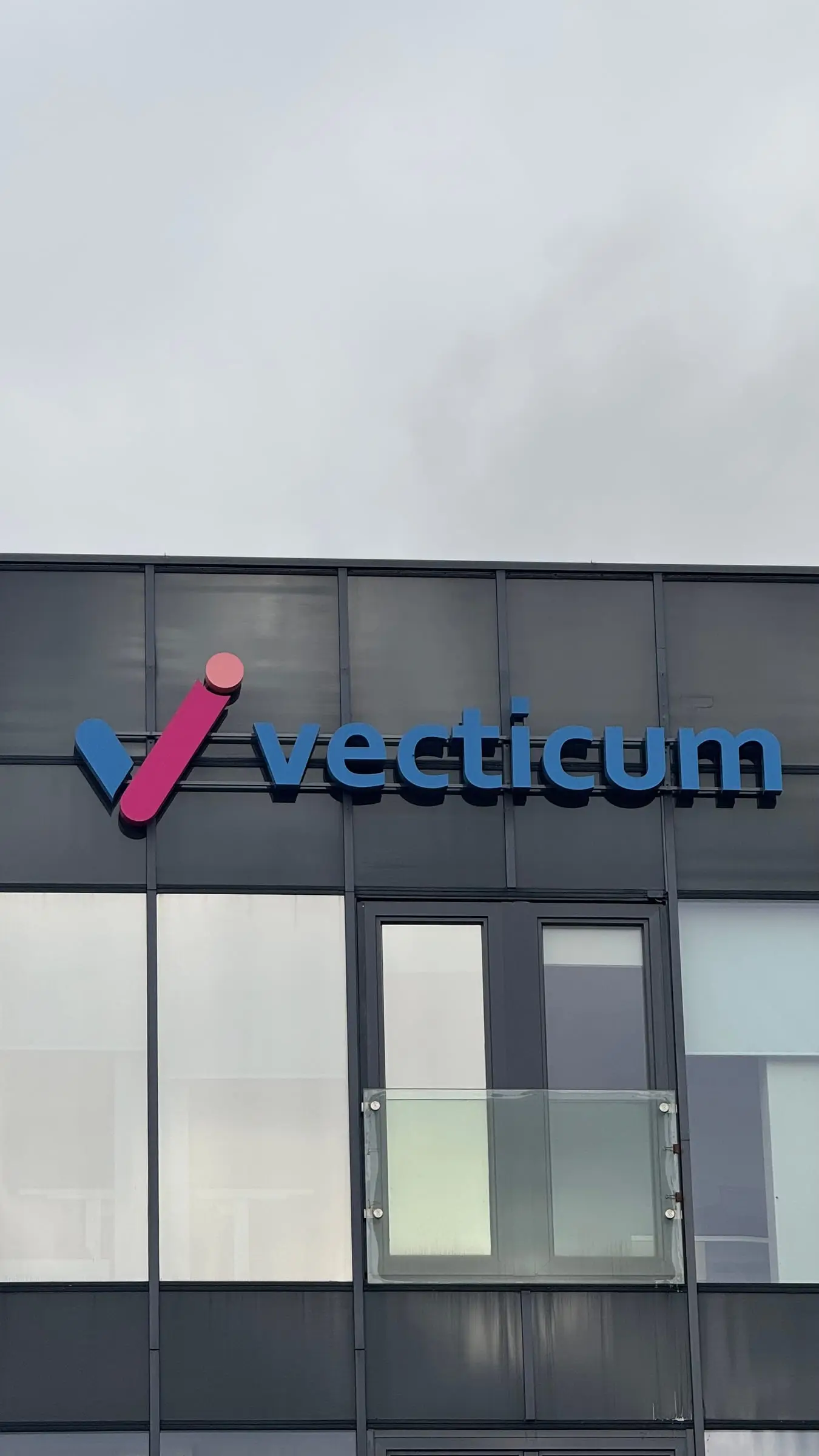 Vecticum tūrinis logotipas ant biurų pastato fasado