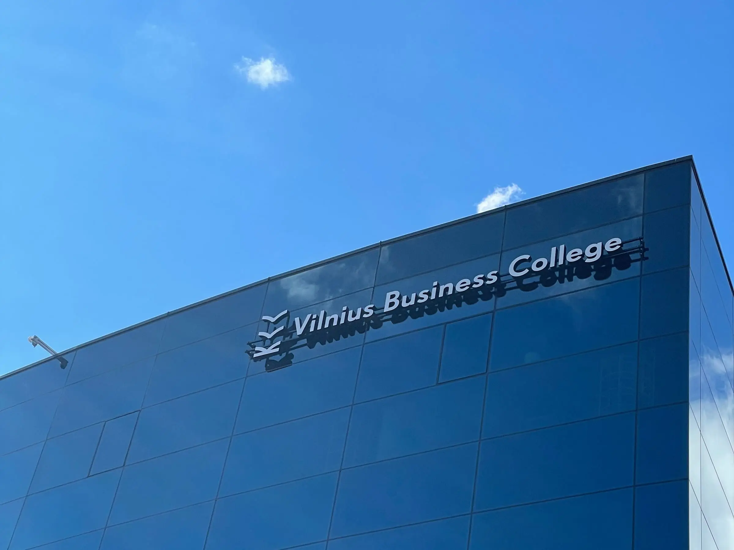Vilnius Business College raidės ant mėlyno stiklinio fasado